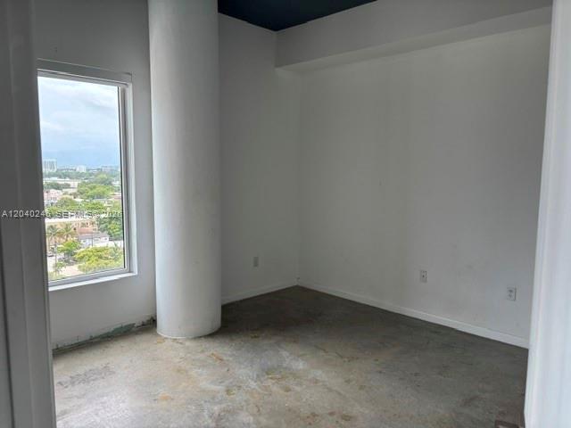 An empty room features white walls, a large structural column, and a window with city views — 10 SW South River Dr # 1109, Miami FL 33130, MIAMI, FL