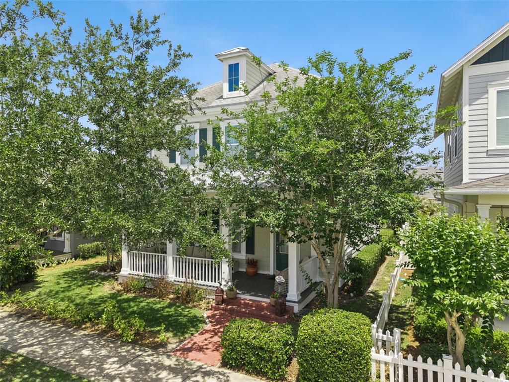 A two-story house with a front porch, dormer window, and white picket fence — 907 EASLEY AVENUE, WINTER GARDEN, FL