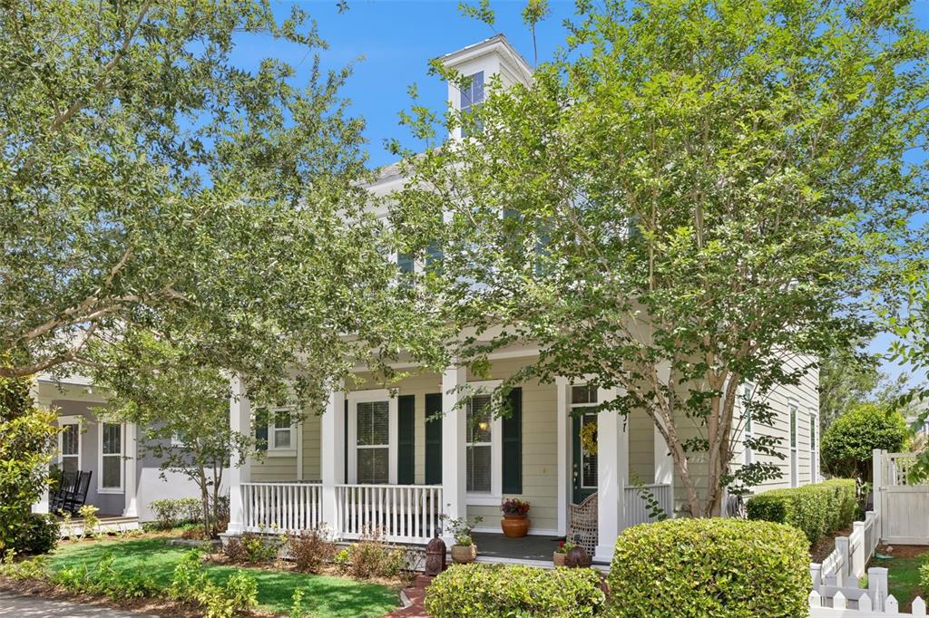 A two-story house with light green siding, a front porch, and mature trees in front — 907 EASLEY AVENUE, WINTER GARDEN, FL