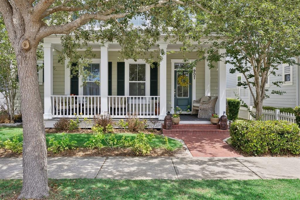 A light green house with a front porch, white railings, and a brick walkway — 907 EASLEY AVENUE, WINTER GARDEN, FL