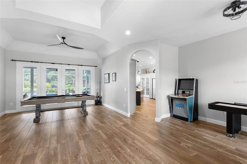 A game room features a pool table, an arcade cabinet, and a shuffleboard table on wood floors — 113 SANDY OAKS PLACE, LONGWOOD, FL