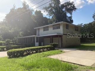 A two-story house with a screened-in porch, two garage doors, and a concrete driveway — 13814 NW 158TH AVENUE, ALACHUA, FL