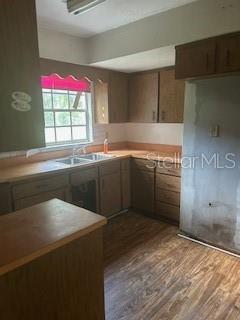 A kitchen with wood cabinets, laminate countertops, a window, and wood-look flooring — 13814 NW 158TH AVENUE, ALACHUA, FL