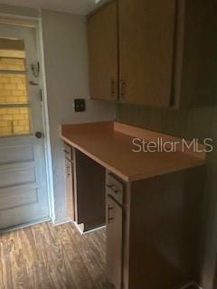 A kitchen area features wood cabinets, a laminate countertop, and a door leading outside — 13814 NW 158TH AVENUE, ALACHUA, FL