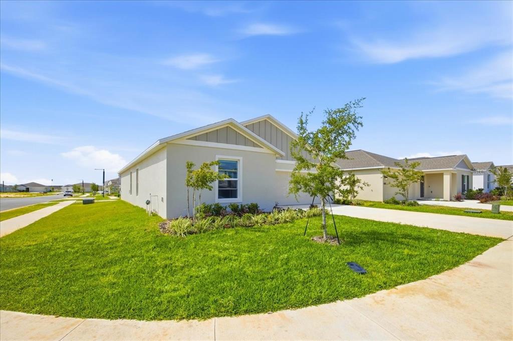A single-story house with a light-colored exterior, a concrete driveway, and a manicured lawn — 2350 MCKINLEY DRIVE, LAKE WALES, FL