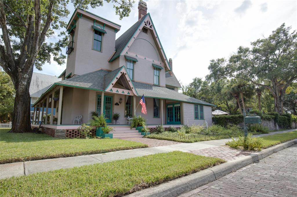 A two-story Victorian-style house with a wraparound porch, a tower, and a brick walkway — 101 READ STREET, TARPON SPRINGS, FL