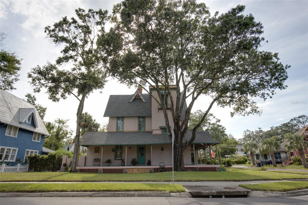A two-story house with a wrap-around porch and a large tree in the front yard — 101 READ STREET, TARPON SPRINGS, FL