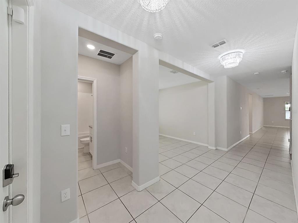 A tiled entryway leads to a hallway, a bathroom, and an open living area — 10384 SCARLET SKIMMER, RIVERVIEW, FL