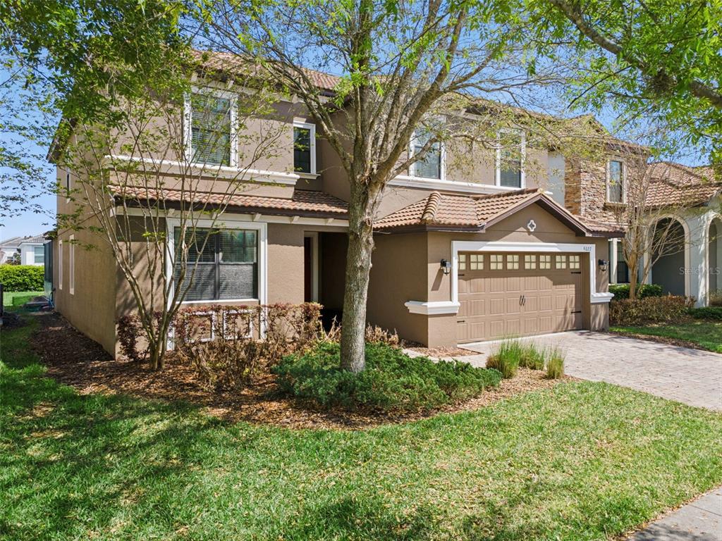 A two-story house with a brown stucco exterior, a tiled roof, and a two-car garage — 9027 SHADOW MOUNTAIN STREET, DAVENPORT, FL