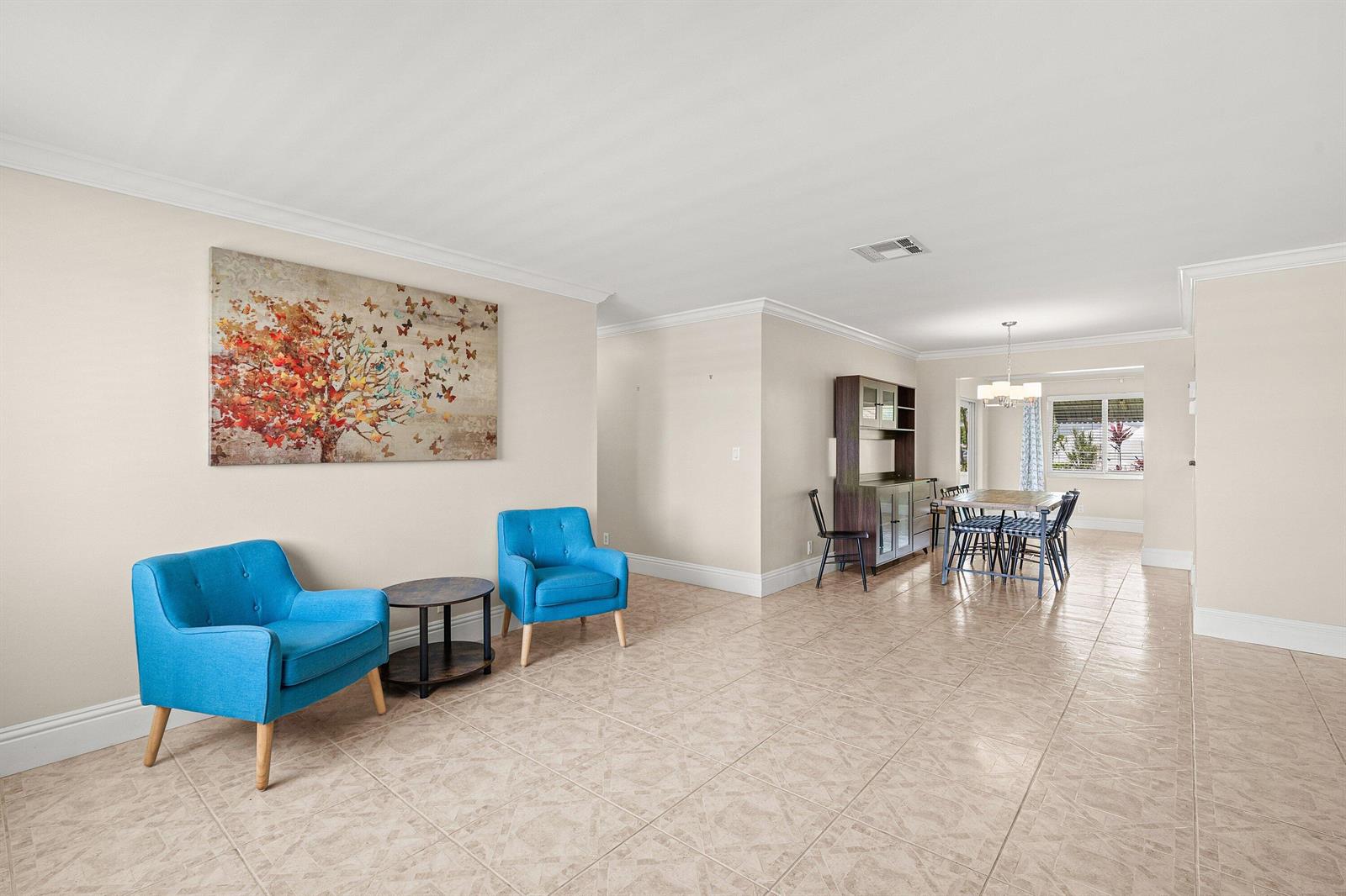 A living and dining area with tiled floors, two blue chairs, and a dining set — 2105 SW 14th Place, Boynton Beach FL 33426, BOYNTON BEACH, FL