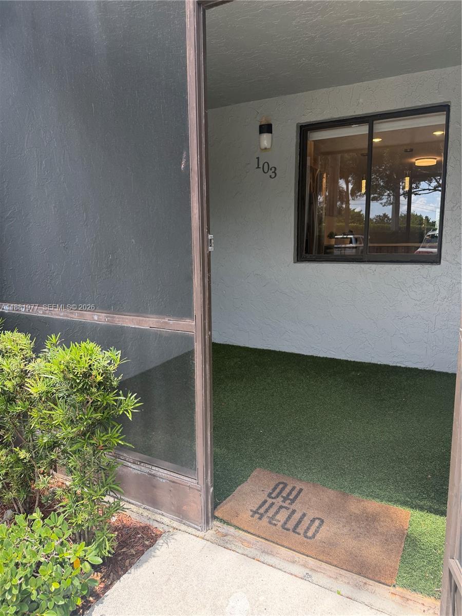 A ground-level patio with artificial turf, a screen door, and a welcome mat — 16531 Blatt Blvd # 103, Weston FL 33326, WESTON, FL
