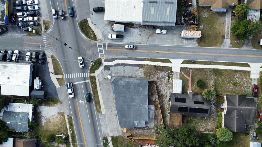 An aerial view shows a commercial building, a residential house, and a street intersection — 2595 AVENUE G NW, WINTER HAVEN, FL