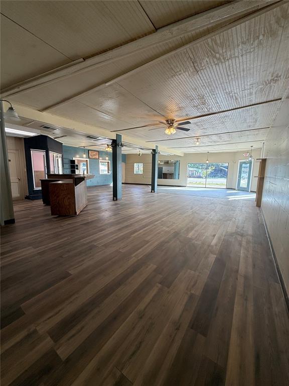 An open-concept commercial space features wood-look flooring, a central wooden counter, and a paneled ceiling — 2595 AVENUE G NW, WINTER HAVEN, FL