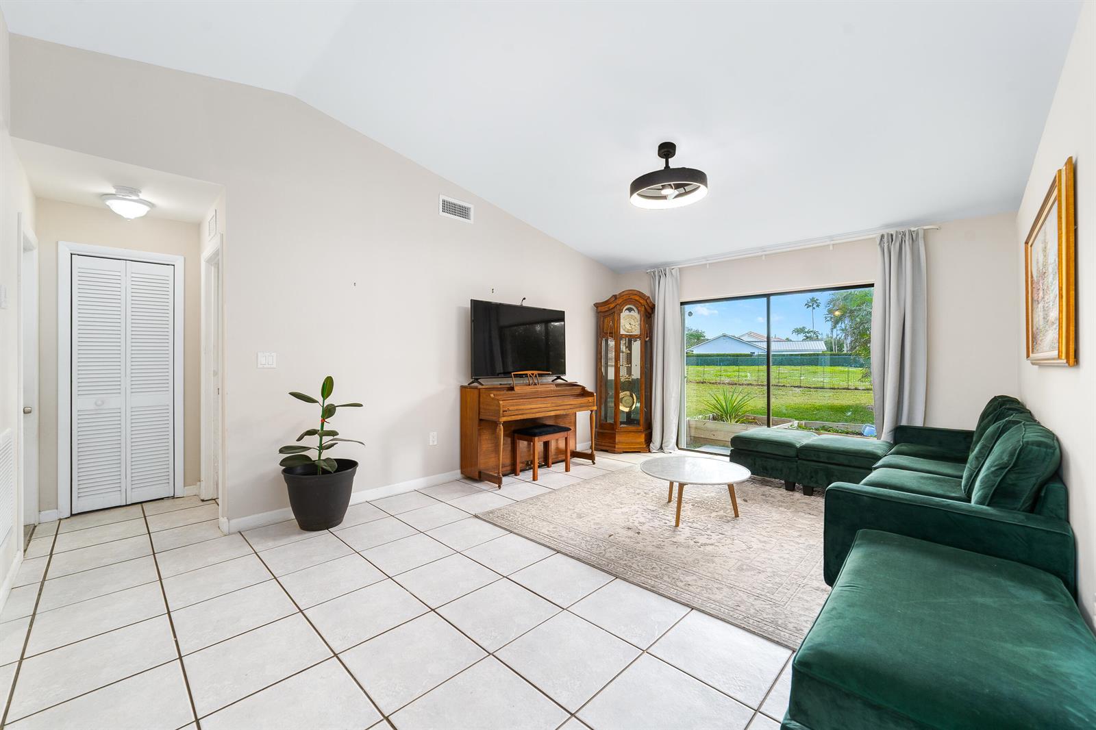 A living room features white tile floors, a green sectional sofa, and a piano — 1060 Cedar Creek Way, Davie FL 33325, DAVIE, FL