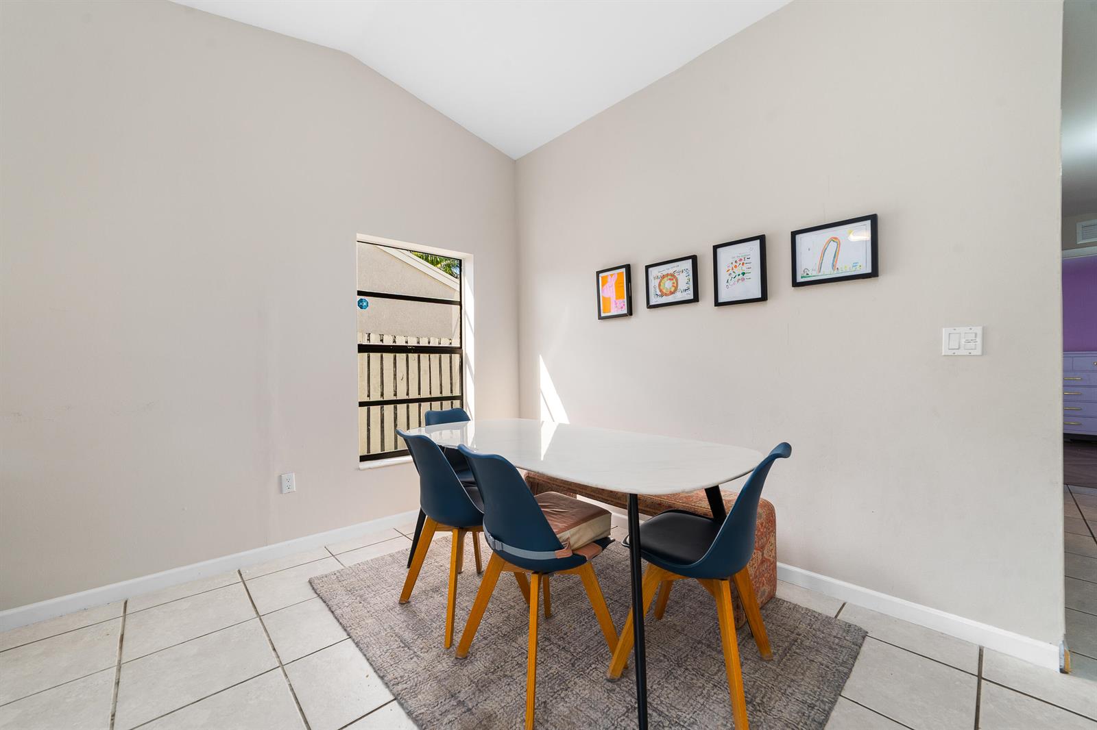 A dining area features a white table, blue chairs, a bench, and framed wall art — 1060 Cedar Creek Way, Davie FL 33325, DAVIE, FL