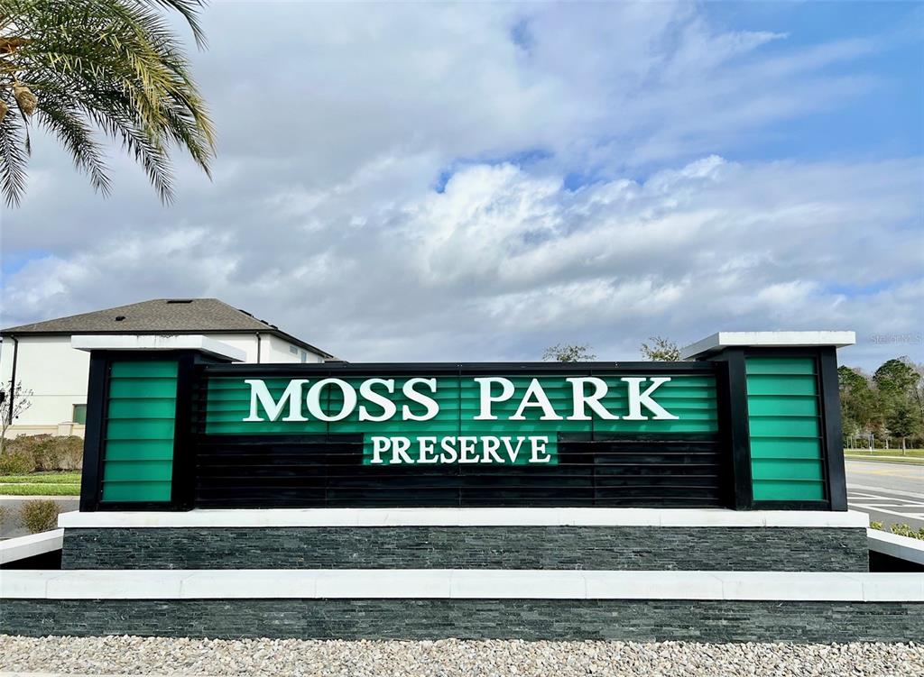 A black and green monument sign for Moss Park Preserve stands outdoors under a cloudy sky — 9359 JUNIPER MOSS CIRCLE, ORLANDO, FL