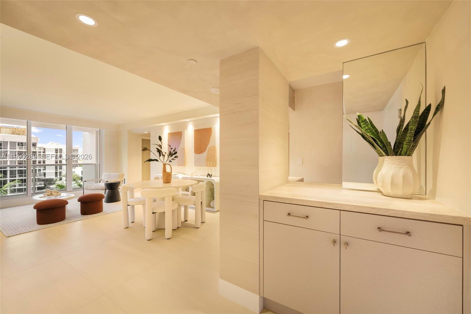 A bright dining area and entryway feature light-colored cabinetry, modern furniture, and floor-to-ceiling windows — 2301 Collins Ave # 526, Miami Beach FL 33139, MIAMI BEACH, FL