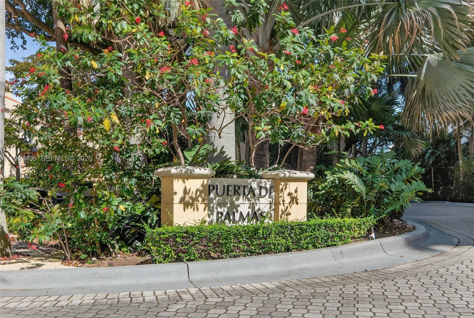 A stone monument sign reading Puerta de Palmas sits amidst lush landscaping and palm trees — 888 S Douglas Rd # 1204, Coral Gables FL 33134, CORAL GABLES, FL