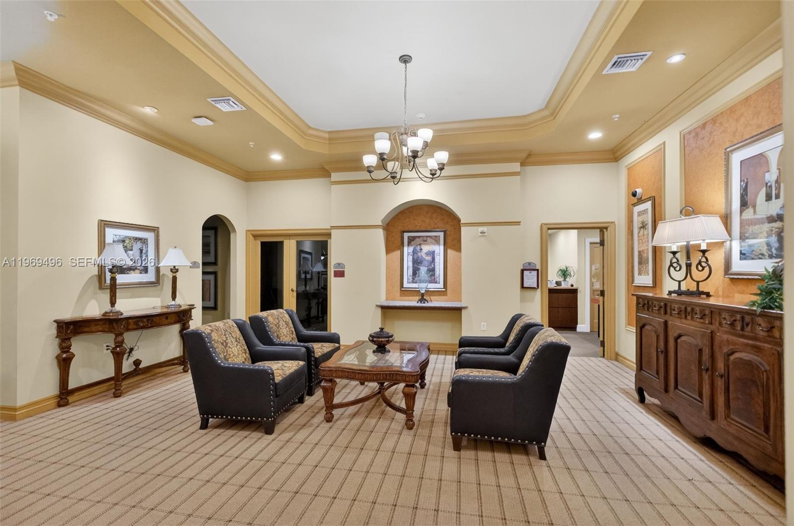 A formal lobby features a coffered ceiling, patterned carpet, and traditional furniture arranged for seating — 888 S Douglas Rd # 1204, Coral Gables FL 33134, CORAL GABLES, FL