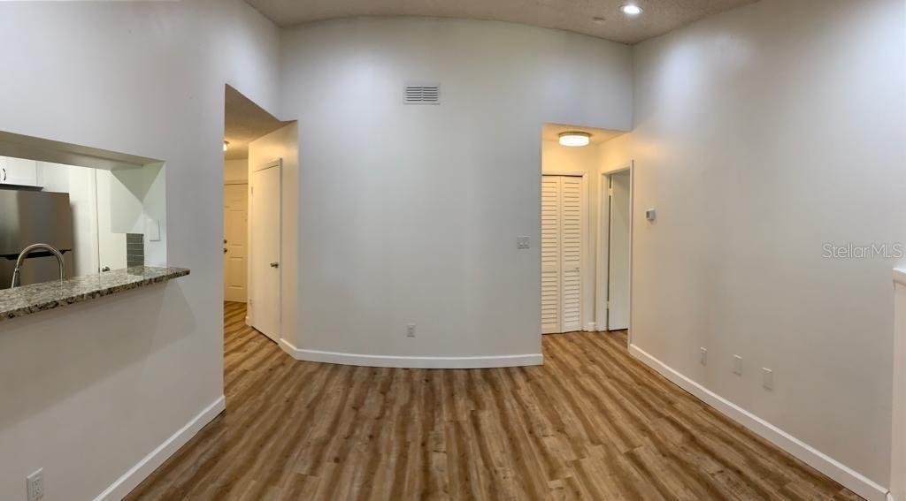 An interior view shows a living area with wood-look flooring and a kitchen pass-through window — 8625 MALLARD RESERVE DRIVE UNIT 204, TAMPA, FL