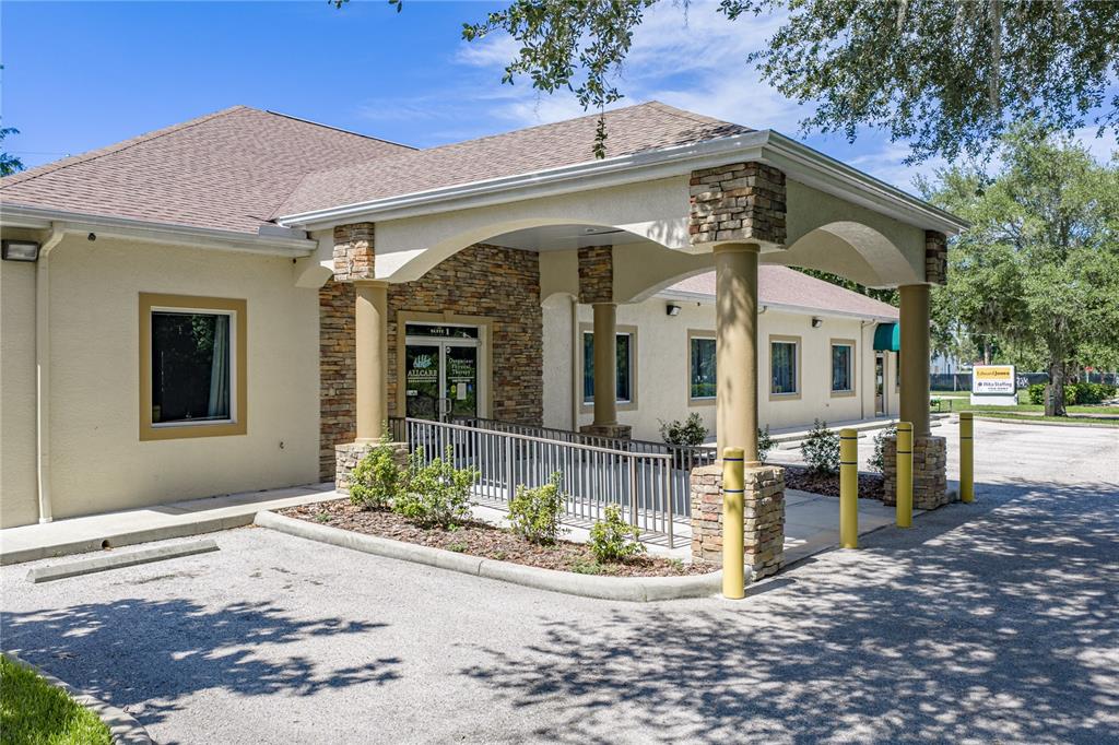 The exterior of a single-story commercial building features a stone-accented entrance with a covered walkway — 1214 W REYNOLDS STREET UNIT 1, PLANT CITY, FL