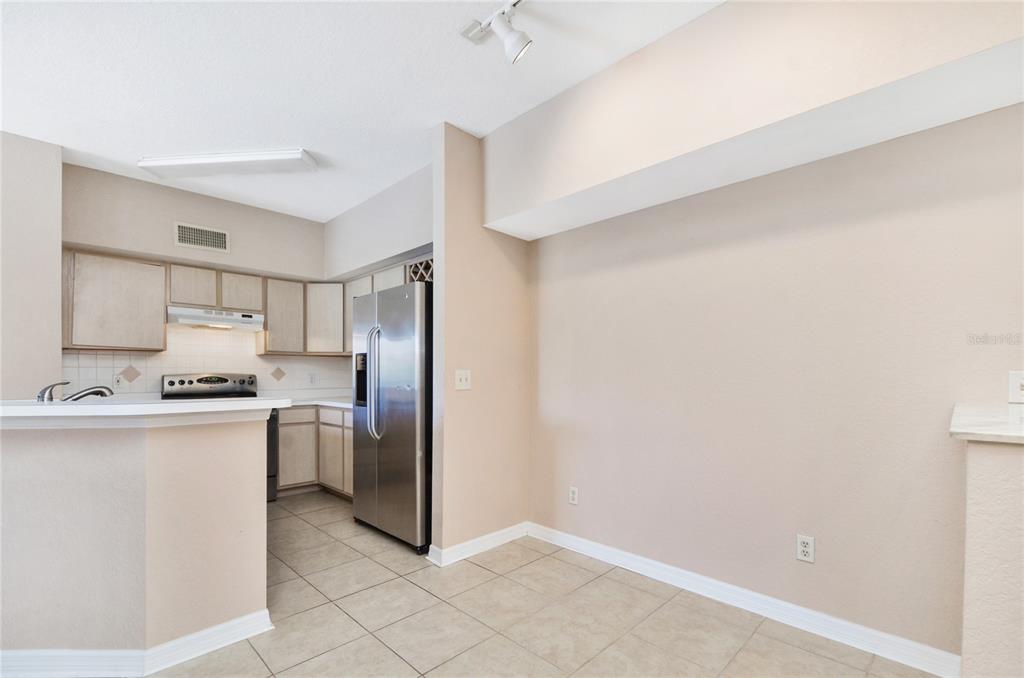 A kitchen with light wood cabinets, stainless steel appliances, and tile flooring — 826 CAMARGO WAY UNIT 210, ALTAMONTE SPRINGS, FL