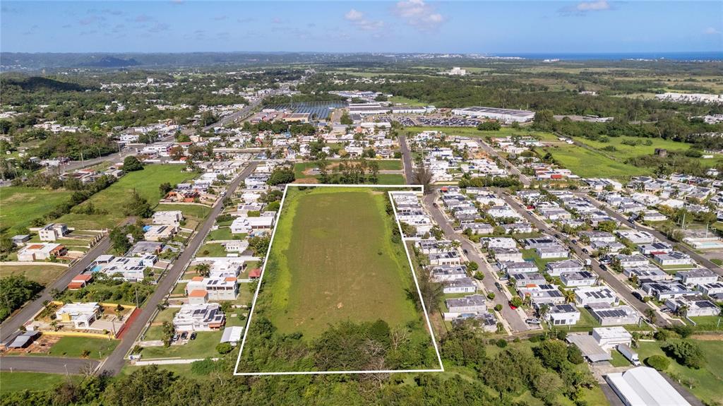 An aerial view shows a rectangular vacant lot outlined in white amidst a residential neighborhood — 682 SANTANA ROAD, ARECIBO, PR