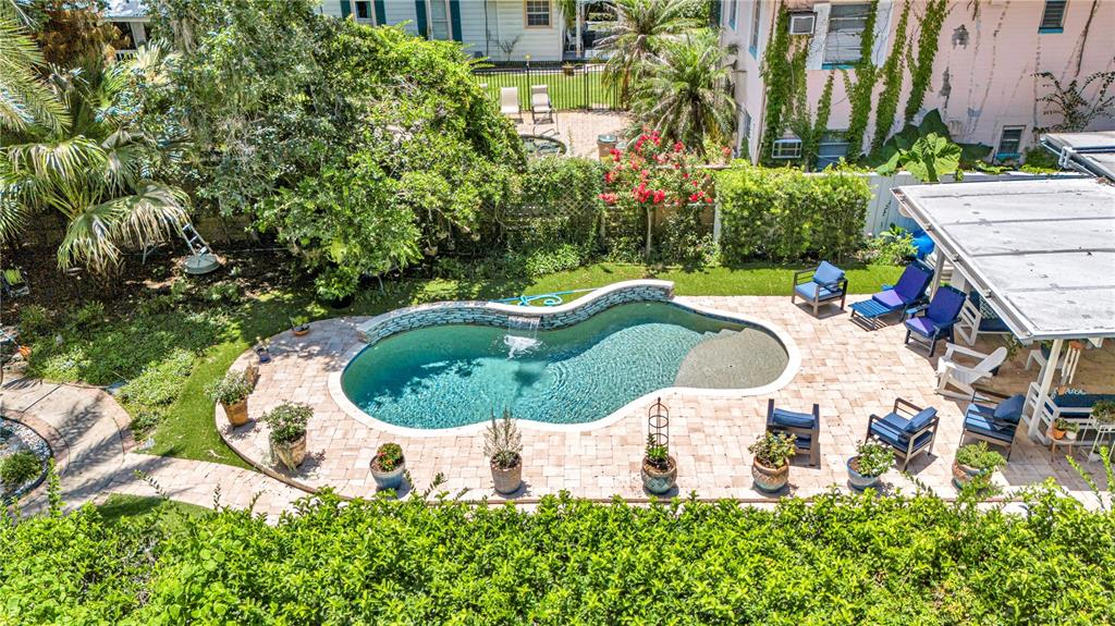 An aerial view shows a backyard with a curved swimming pool and patio furniture — 55342 CLAIRE STREET, ASTOR, FL