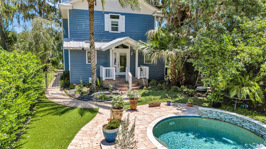 A blue two-story house features a brick patio with a small circular swimming pool — 55342 CLAIRE STREET, ASTOR, FL