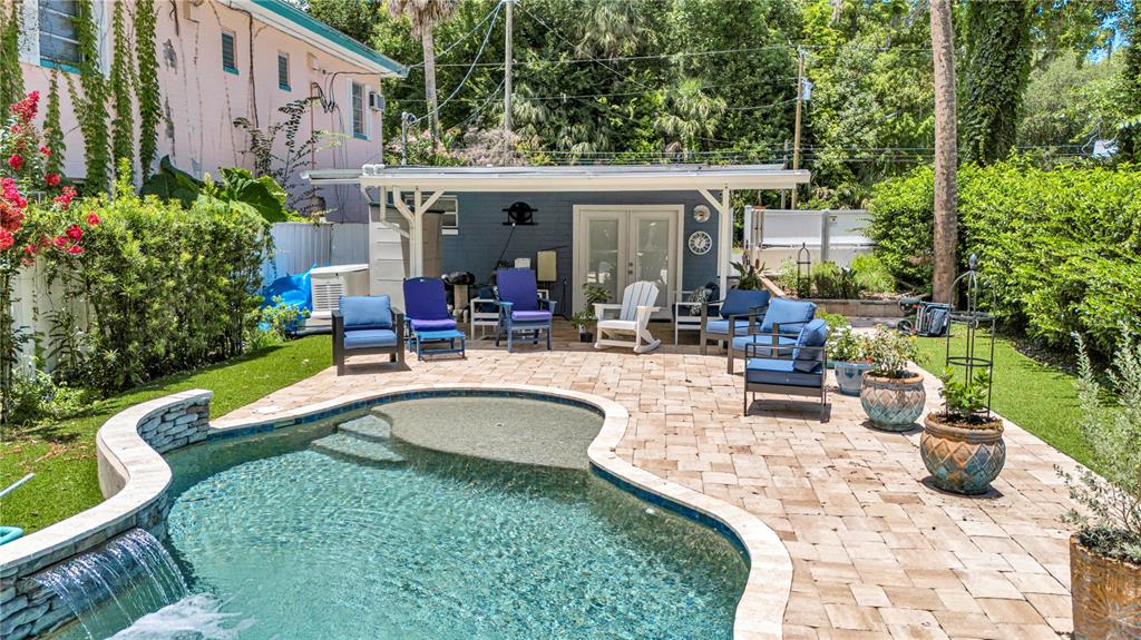 A backyard features a swimming pool with a waterfall, a paved patio, and a guest house — 55342 CLAIRE STREET, ASTOR, FL