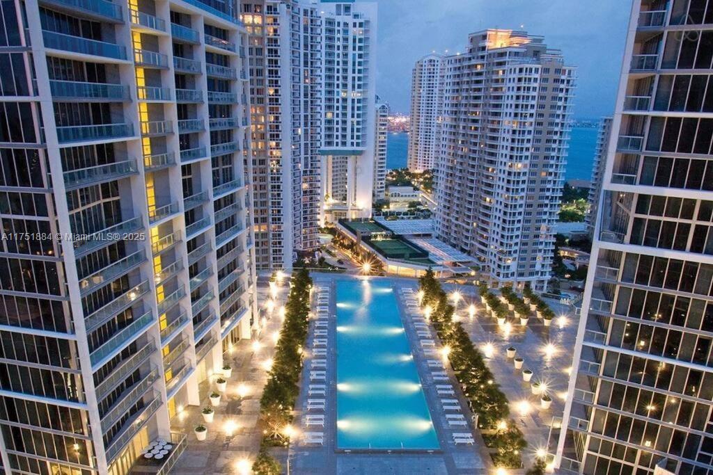 An aerial view of a long swimming pool situated between several modern high-rise apartment buildings — 465 Brickell Ave # 2405, Miami FL 33131, MIAMI, FL