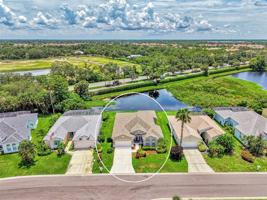 An aerial view shows a single-story house with a tan roof and driveway facing a street — 6339 STURBRIDGE COURT, SARASOTA, FL