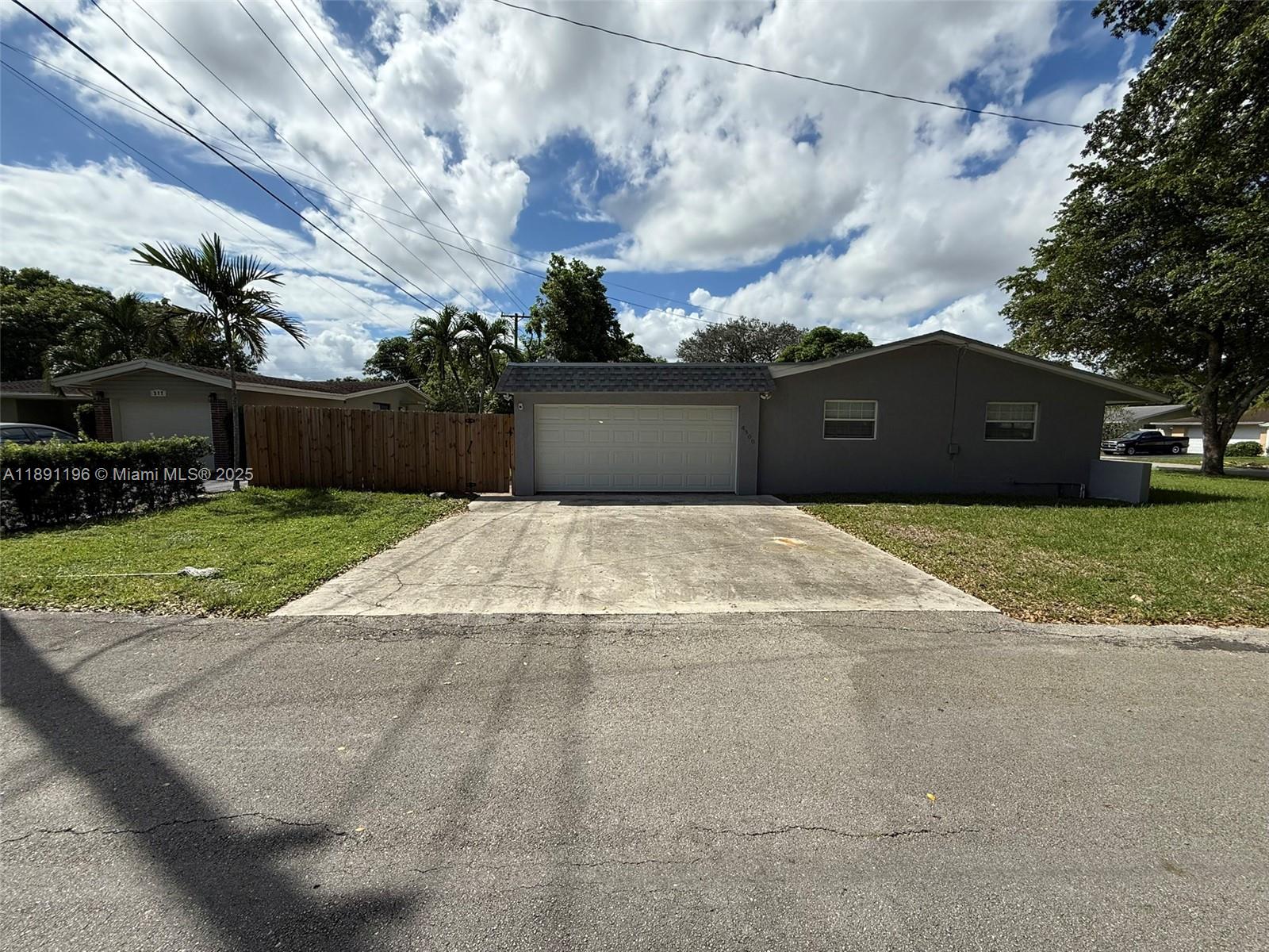 A gray single-story house features a white garage door and a concrete driveway — 4300 NW 3rd Ct # 1, Plantation FL 33317, PLANTATION, FL