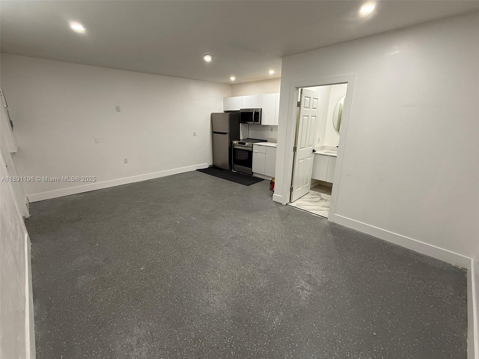 A studio apartment features a kitchenette, gray speckled flooring, and an attached bathroom — 4300 NW 3rd Ct # 1, Plantation FL 33317, PLANTATION, FL