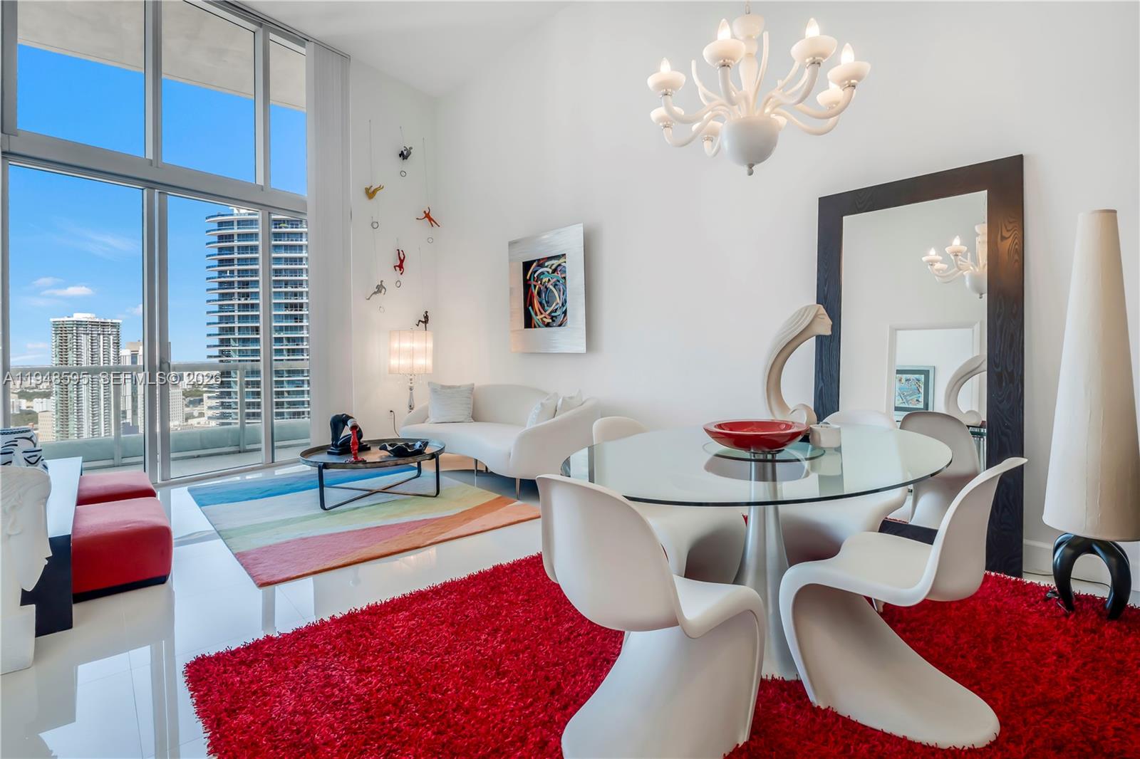 A modern living and dining area with white furniture, a red rug, and floor-to-ceiling windows — 465 Brickell Ave # 4106, Miami FL 33131, MIAMI, FL