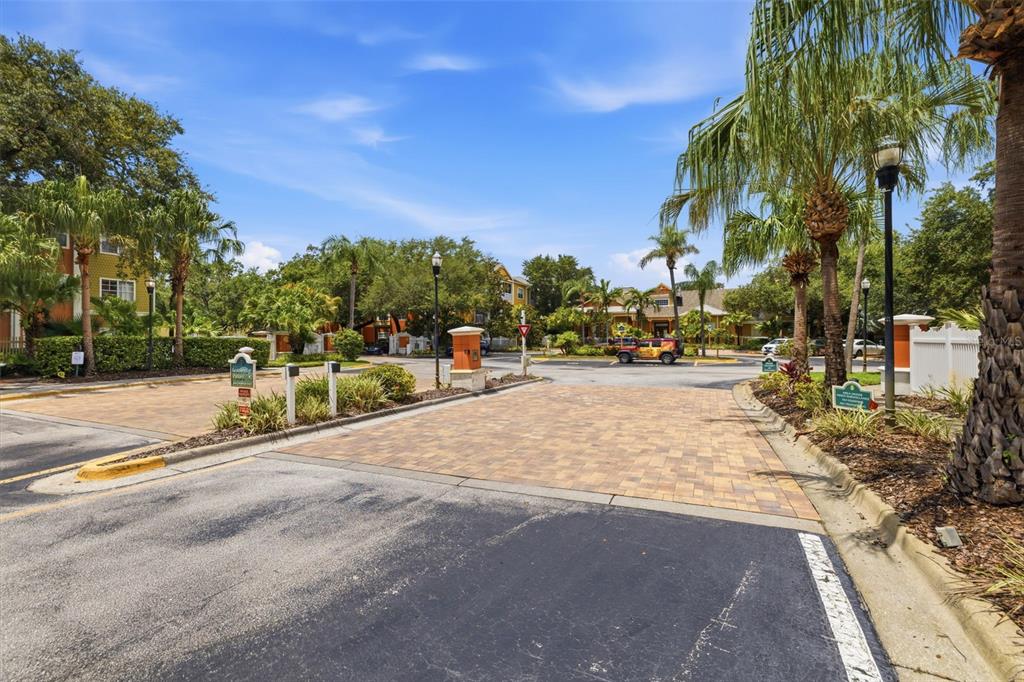 A paved entrance leads into a residential complex with palm trees and multi-story apartment buildings — 4207 S DALE MABRY HIGHWAY UNIT 2305, TAMPA, FL