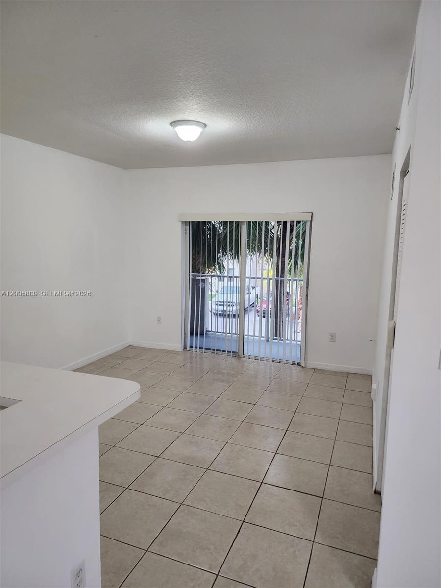 A dining area features tiled floors, a ceiling light, and a sliding glass door — 11060 SW 196th St # 209, Cutler Bay FL 33157, CUTLER BAY, FL