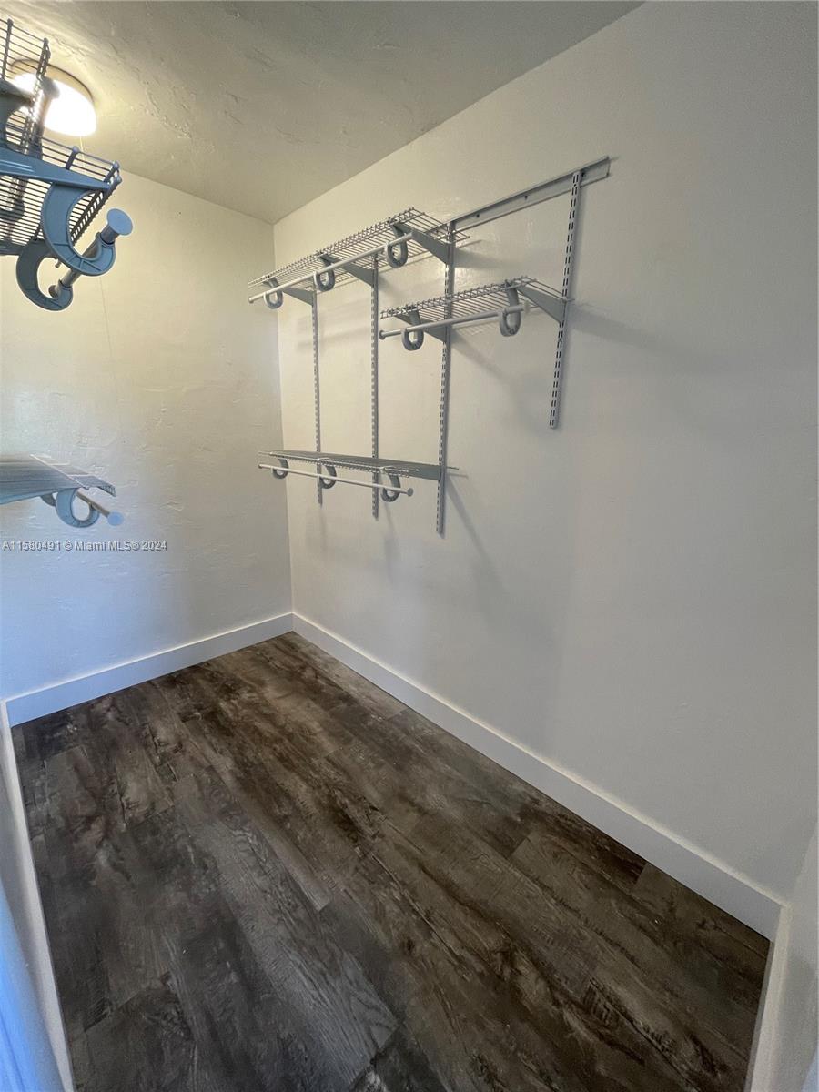 A walk-in closet features white wire shelving units mounted on walls over wood-look flooring — 760 Jefferson Ave # 11, Miami Beach FL 33139, MIAMI BEACH, FL