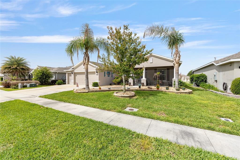 A single-story suburban house features a landscaped front yard with palm trees and a driveway — 4258 JAMES RIVER CIRCLE, LEESBURG, FL