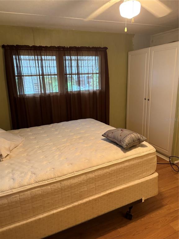 A bedroom features a mattress on a metal frame, a window with curtains, and cabinets — 6580 SEMINOLE UNIT 102, SEMINOLE, FL