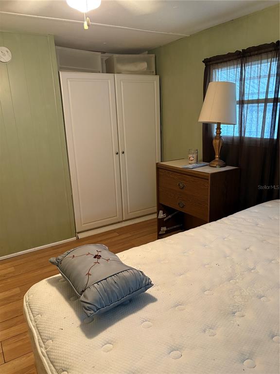 A bedroom features a white wardrobe, a wooden nightstand with a lamp, and a mattress — 6580 SEMINOLE UNIT 102, SEMINOLE, FL