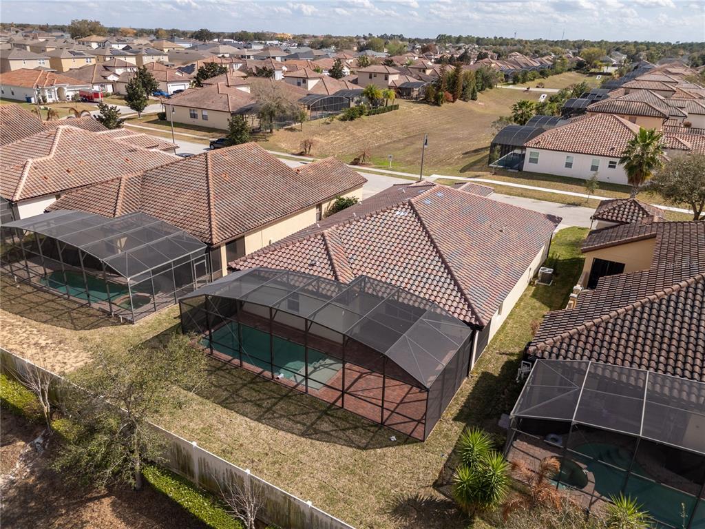 An aerial view shows several suburban houses with screened-in swimming pools and tiled roofs — 355 VILLA SORRENTO CIRCLE, HAINES CITY, FL