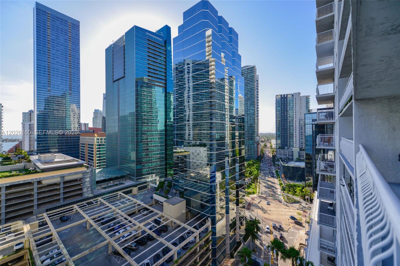 An elevated view shows a dense urban skyline with modern glass skyscrapers and a parking structure — 1200 Brickell Bay Dr # 2119, Miami FL 33131, MIAMI, FL