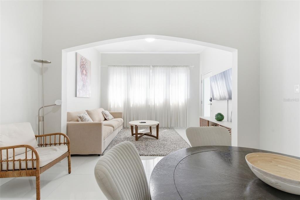 A living room with a beige sofa and coffee table is viewed through an arched opening — 56 CALLE F KRUG CONDADO UNIT 1, SAN JUAN, PR