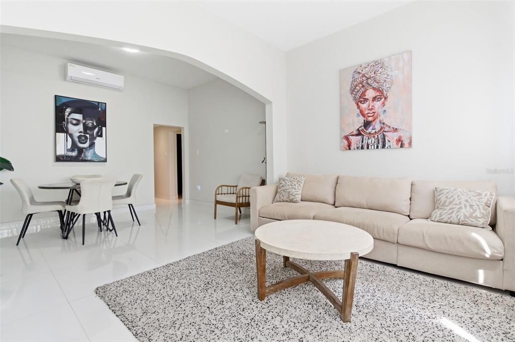 A living room with a beige sofa, round coffee table, and dining area under an archway — 56 CALLE F KRUG CONDADO UNIT 1, SAN JUAN, PR