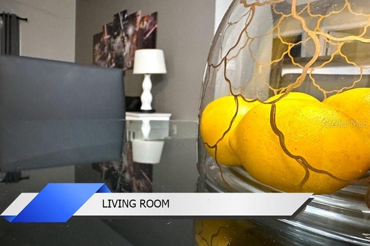 A glass bowl of lemons sits on a dark table in a living room — 8112 POINCIANA BOULEVARD UNIT 1502, ORLANDO, FL