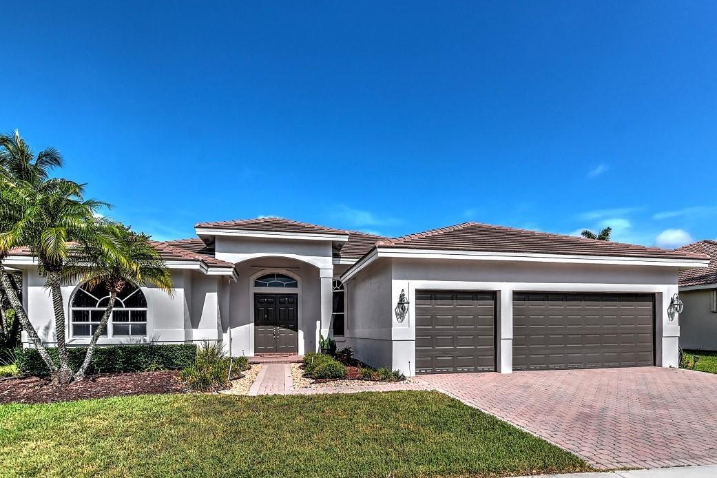 A single-story house with a tiled roof, two-car garage, and a paved driveway — 1125 Waterside Circle, Weston FL 33327, WESTON, FL