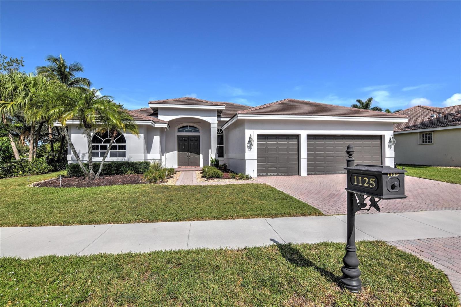 A single-story house with a two-car garage, a tiled roof, and a front mailbox — 1125 Waterside Circle, Weston FL 33327, WESTON, FL
