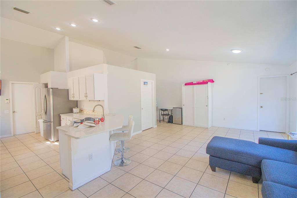 An open-concept living area features a kitchen with white cabinets, a breakfast bar, and tile flooring — 10606 WALKER VISTA DRIVE, RIVERVIEW, FL
