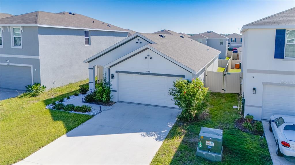 An exterior view of a single-story suburban house with a white garage and driveway — 8695 SW 46TH AVENUE, OCALA, FL